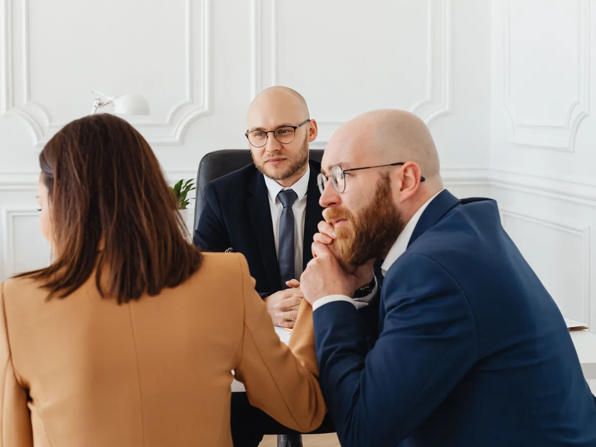 Three people talking through a project across a table