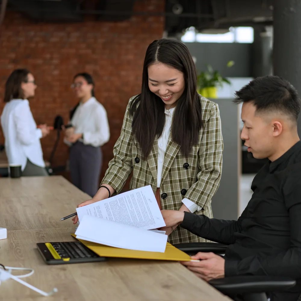 Two colleagues going through project documents together