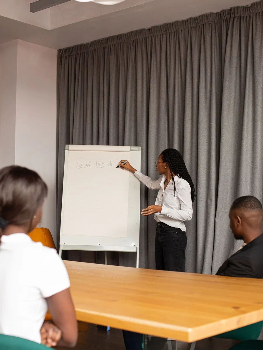 Trainer working through team-working principles on a flip chart with a small group